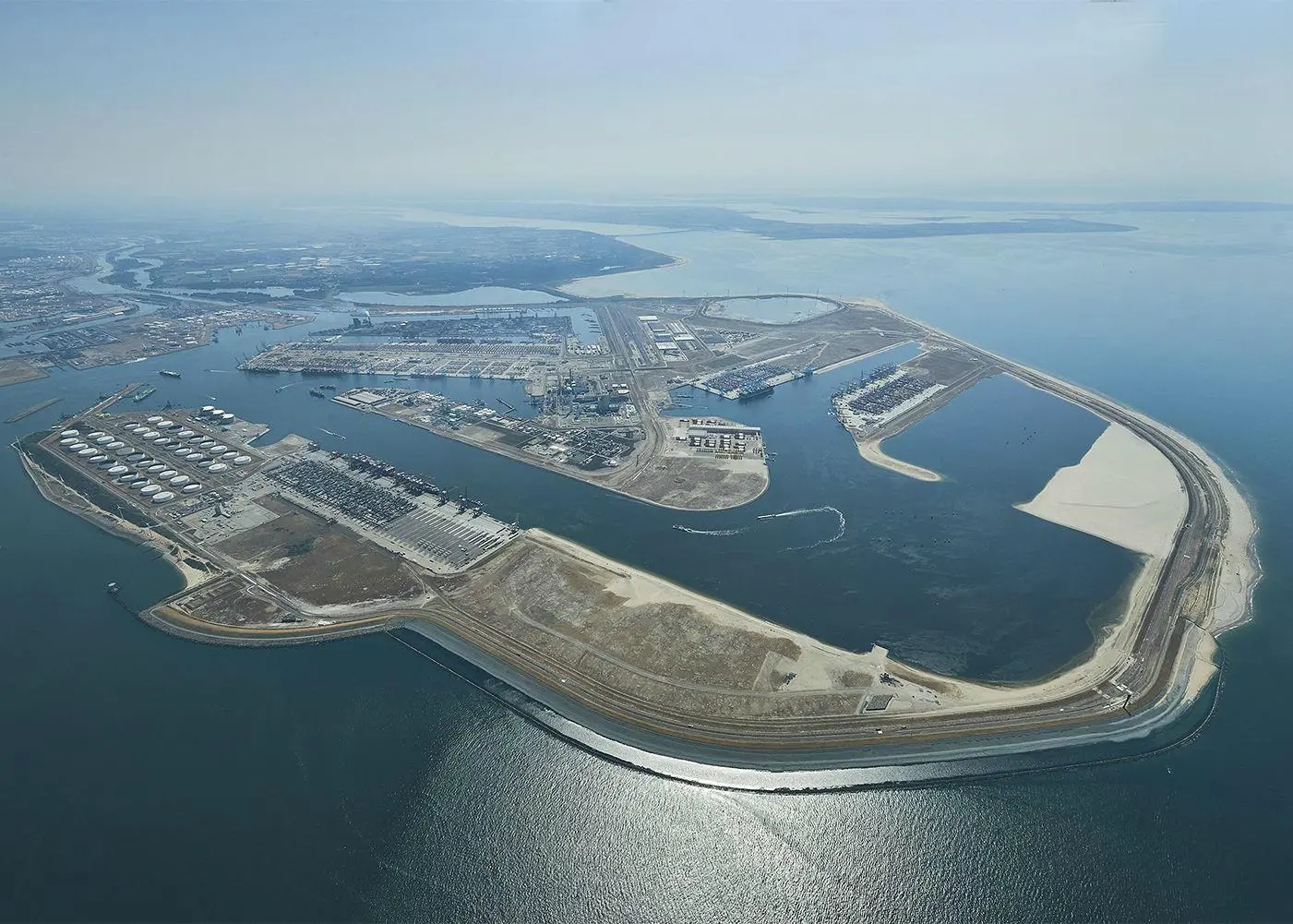 Container ships at a busy port terminal with cranes loading and unloading containers.