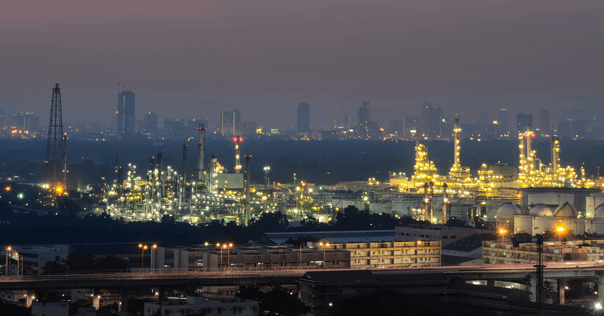 A refinery complex with industrial structures and pipelines, possibly with a carbon capture unit visible.